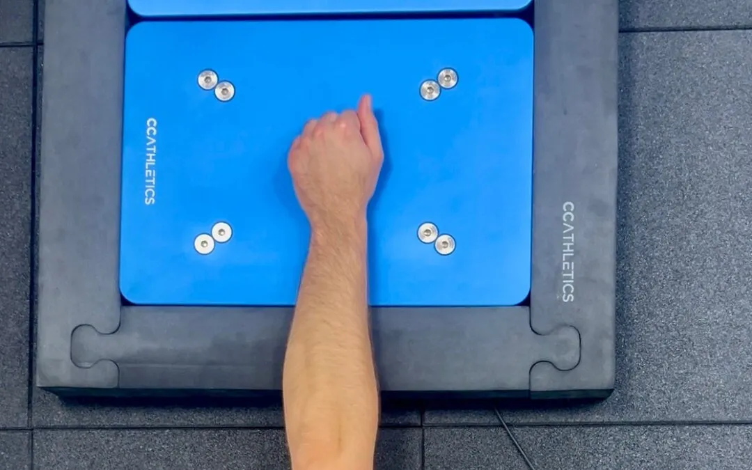 Overhead view of an athlete pressing a fist down onto a PlateMate force plate during the Athletic Shoulder test